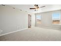 A light and airy bedroom is showcased with neutral walls, plush carpet, and ample natural light from large windows at 9474 Yampa St, Commerce City, CO 80022