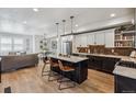 Bright, open kitchen with island seating, stainless steel appliances, and a view of the adjacent living and dining areas at 5423 S Prince St # B, Littleton, CO 80120