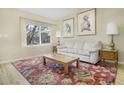 Bright living room featuring a large window, a neutral sofa, and hardwood floors with colorful rug at 4820 W 125Th Ave, Broomfield, CO 80020