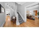 Elegant entryway with a curved staircase, hardwood floors, and views into the living room at 4045 E 18Th Ave, Denver, CO 80220