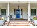 Inviting front porch with white columns, stylish railing, and a bright blue front door with decorative screen at 4045 E 18Th Ave, Denver, CO 80220