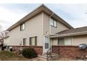 Tan two-story condo building with brick base and landscaping at 9255 E Lehigh Ave # 211, Denver, CO 80237