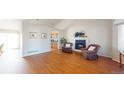 Bright living room with cozy fireplace, vaulted ceilings, and hardwood floors, open to the kitchen at 8910 Rutgers St, Westminster, CO 80031