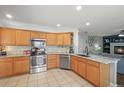 Well-lit kitchen with stainless steel appliances, granite counters, and tile backsplash at 2602 E 145Th Ave, Thornton, CO 80602