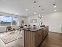 Open-concept living area combines a modern kitchen with a cozy seating area near a window at 1898 S Bannock St # 209, Denver, CO 80223