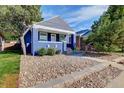 Beautiful shot of the home's blue painted brick, gabled roof, front yard, and charming curb appeal at 706 S Lincoln St, Denver, CO 80209