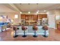 Spacious kitchen features an island with bar seating, stainless steel appliances, and wooden cabinetry at 8537 E 35Th Ave, Denver, CO 80238