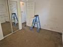 Bedroom with a mirrored closet, ladder, and a to-do list written on the mirror at 4678 S Lewiston Way, Aurora, CO 80015