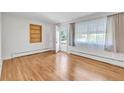 Bright, empty living room with hardwood floors and large windows offering lots of natural light at 505 Maple St, Golden, CO 80403