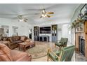 Spacious living room with a cozy fireplace, ceiling fans, and large entertainment center at 1428 S County Road 23E, Berthoud, CO 80513