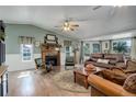 Comfortable living room with wood floors, fireplace, ceiling fan, and plenty of natural light at 1428 S County Road 23E, Berthoud, CO 80513