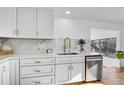 Bright kitchen showcasing white cabinets, stainless steel appliances, quartz countertops, and hardwood flooring at 4642 Everett Ct, Wheat Ridge, CO 80033