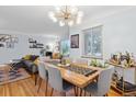 Open-concept dining area with modern chandelier, stylish furniture and hardwood floors at 2681 Leyden St, Denver, CO 80207
