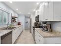 Modern kitchen with white cabinetry, stainless steel appliances, and granite countertops at 2681 Leyden St, Denver, CO 80207