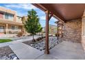 View of the front of the home with decorative rocks and landscaping, covered porch, and attractive townhome community at 11294 Bella Vita Dr, Broomfield, CO 80020