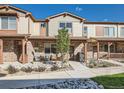 Charming townhome with stone accents, front porch, and well-manicured landscaping at 11294 Bella Vita Dr, Broomfield, CO 80020