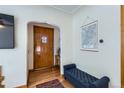 Inviting entryway with hardwood floors, a wooden door with glass accents, and a comfortable bench at 1120 Holly St, Denver, CO 80220