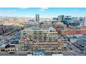 Aerial image showcasing a modern city building with surrounding urban development and mountain views at 1499 Blake St # 5D, Denver, CO 80202