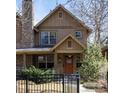 Charming home featuring a stone chimney, well-manicured landscaping, and inviting front porch at 2042 S Clayton St, Denver, CO 80210