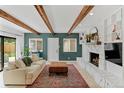 Inviting living room featuring vaulted ceilings with beams, a fireplace, and access to the backyard at 9790 E 5Th Ave, Aurora, CO 80010