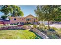 Charming brick home featuring a lush front yard with stone accents and mature landscaping at 3570 W Pimlico Ave, Englewood, CO 80110