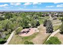 Scenic aerial view of a neighborhood park with a playground, walking paths, and lush green trees at 20855 Park Hollow Dr, Parker, CO 80138