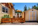 Side view of the property with a detached shed and a deck featuring an outdoor dining set with umbrella at 4805 S Blue Spruce Rd, Evergreen, CO 80439