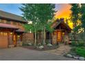 Beautiful home entrance featuring stone accents, wood trim, and manicured landscaping at 805 Highfield Trl, Breckenridge, CO 80424