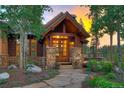 Close-up of the front entryway with beautiful woodwork, stone pillars, and a stone walkway at 805 Highfield Trl, Breckenridge, CO 80424