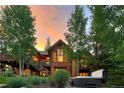 Beautiful rear exterior showcasing a deck, hot tub, lush landscaping, and nice architectural features at 805 Highfield Trl, Breckenridge, CO 80424
