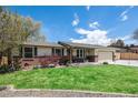 Beautiful ranch-style home with brick accents and a well-manicured lawn, offering a welcoming curb appeal under a blue sky at 7960 Estes Ct, Arvada, CO 80005