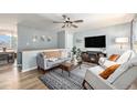 Open living room offers wood floors, a ceiling fan, comfortable seating, and a cozy fireplace for relaxing entertainment at 7960 Estes Ct, Arvada, CO 80005