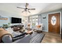 Inviting living room features a ceiling fan, front entry door, and cozy seating around a television and fireplace at 7960 Estes Ct, Arvada, CO 80005