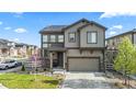 Two-story home features a front yard with green grass, an attached two-car garage and solar panels at 2688 Loon Cir, Castle Rock, CO 80104