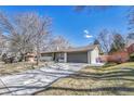 Attractive home with a large driveway, attached garage, and a well-landscaped front yard with mature trees at 3680 S Glencoe St, Denver, CO 80237