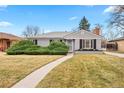Charming gray-painted home with a welcoming walkway and mature landscaping at 1030 Krameria St, Denver, CO 80220