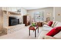 Bright living room with a cozy brick fireplace and neutral carpeting at 1030 Krameria St, Denver, CO 80220