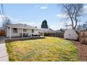 Expansive backyard featuring a well-kept lawn, patio, and storage shed at 1615 S Elizabeth St, Denver, CO 80210
