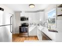 Bright kitchen featuring modern appliances, white cabinets, and a window overlooking the outdoors at 1615 S Elizabeth St, Denver, CO 80210