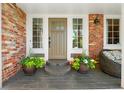Charming front door with brick accents and decorative flower pots, creating an inviting entrance at 11453 E Orchard Pl, Englewood, CO 80111