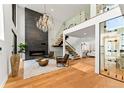 Stunning living room with soaring ceilings, modern fireplace, hardwood floors, and a striking chandelier at 220 Glencoe St, Denver, CO 80220