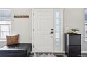 Welcoming front door with sidelight and storage bench with coat rack for organized entry at 1492 Red Cliff Way, Castle Rock, CO 80109