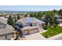Stunning aerial view of a home with solar panels, mature trees, and a beautifully landscaped yard at 58 Rogers Ct, Golden, CO 80401