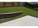Expansive backyard boasts a lush green lawn, a patio area, and a charming stone retaining wall at 5546 S Quemoy Cir, Aurora, CO 80015