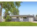 Well-maintained single-story home with a gray brick and white facade and green lawn at 5150 W Colgate Pl, Denver, CO 80236