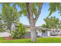 Charming home featuring a gray brick facade and a well-manicured lawn at 5150 W Colgate Pl, Denver, CO 80236