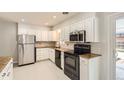 Updated kitchen features stainless steel appliances, white cabinets, and granite countertops at 5150 W Colgate Pl, Denver, CO 80236