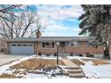 Charming single-story brick home with a two-car garage, a well-manicured lawn, and wintery landscaping at 8094 E Kenyon Pl, Denver, CO 80237