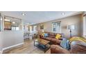 Inviting living room featuring a cozy leather sofa, stylish decor, and an open layout to the dining area at 3282 W 66Th Ave, Denver, CO 80221