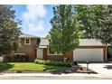 Charming home exterior featuring a well-manicured lawn and mature trees in a serene neighborhood at 1380 Holly E Dr, Broomfield, CO 80020